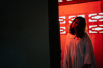 Ghost, zombie, demon A woman dressed up as a ghost in a bloody abandoned house for Halloween.