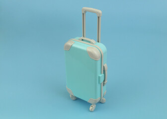 Blue travel suitcase on blue background. Vacation and travel concept.	