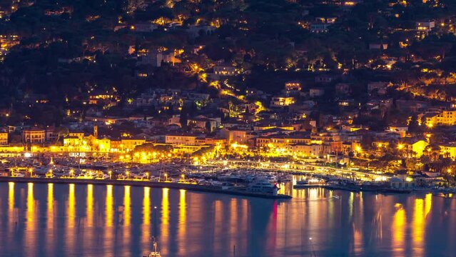 Yachts in port of Saint-Jean-Cap-Ferrat day to night transition aerial timelapse. Resort and commune in southeast of France on promontory of Cote d'Azur in Provence-Alpes-Cote d'Azur region, France