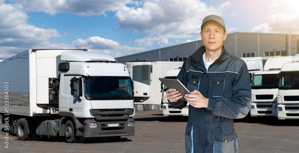 Poster manager with a digital tablet on the background of trucks. fleet management