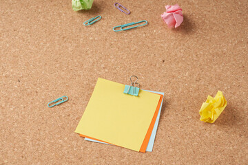 Several multi-colored sheets of paper fastened with a paper clip.