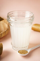 Fresh cane juice and brown sugar on a beige background, closeup. Vertically.