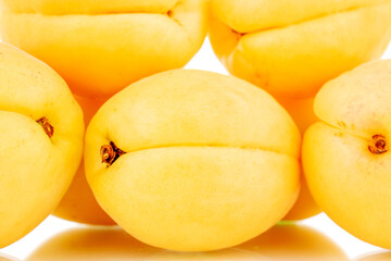 Naklejka na ściany i meble Several bright yellow juicy pineapple apricots, macro, isolated on a white background.
