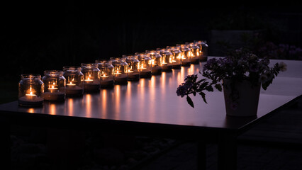 Fototapeta na wymiar 14 Kerzenlichter und eine Blume auf Tischplatte