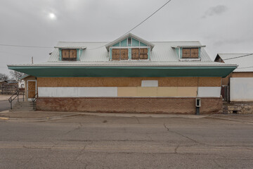 Front of an abandoned store with boarded up windows