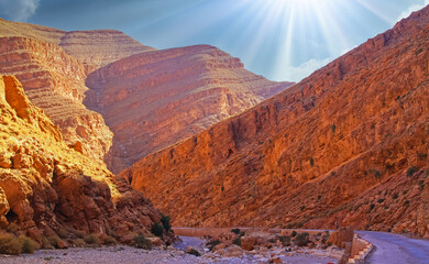 Beautiful red sandstone valley landscape, empty curved road, narrow canyon, morning sun rays -...