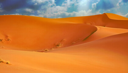 Beautiful empty orange color sand desert dunes landscape, wavy lines, sun rays storm clouds - Sahara Erg Chebbi, Morocco