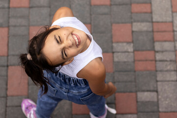Portrait of a young girl in casual clothing on inline skates. Top view.