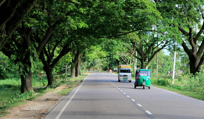 Natural Landscape photo of highway road with both side green trees in Bangladesh.