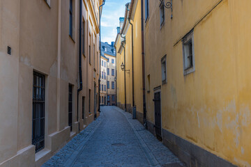 Close up view of narrow street between two yellow buildings. Sweden. Stockholm. 