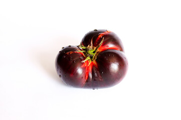 Fresh ripe black tomato isolated on a white background. Krim or Kumato tomatoes.