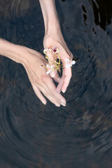 Young woman's hand touching the water in the sea