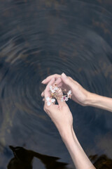 Young woman's hand touching the water in the sea
