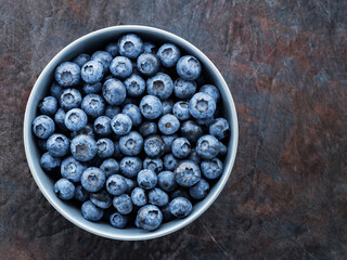 Blueberry bowl on dark background. Fresh blueberries in a gray bowl. Top view. Copy space