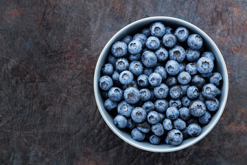 Blueberry bowl on dark background. Fresh blueberries in a gray bowl. Top view. Copy space