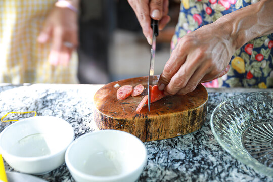 people. man cutting Chinese sausage