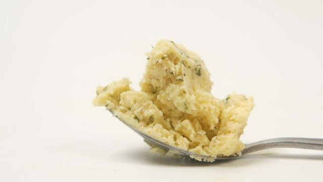 close up of fresh garlic spread on spoon on white 