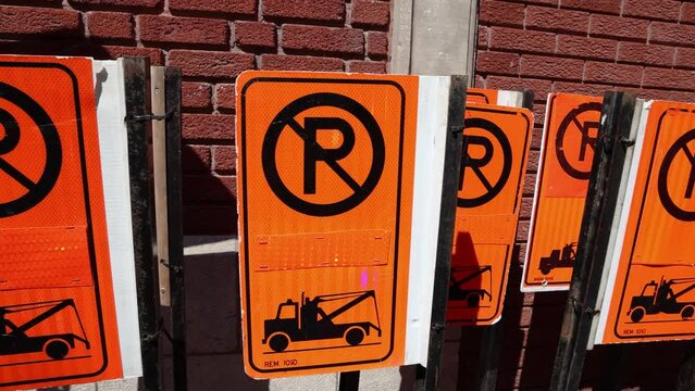 Slow motion movie showing lots of no parking signage and street furniture stored by a local municipality building in central Montreal, Canada.