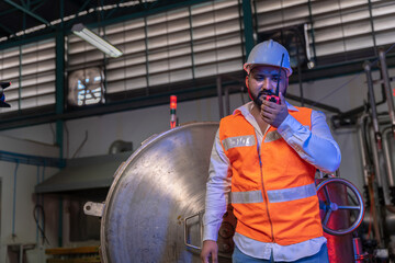 Indian Engineer who takes care of the machines in the factory It is a large heating device in a beverage factory.