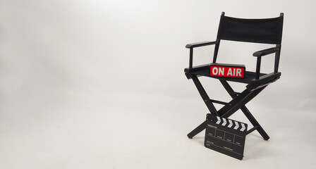 Black director chair and black clapper board and on air box on white background