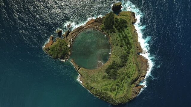 Aerial drone zoom-out shot of small island of Vila Franca do Campo on Sao Miguel. Top view of volcanic atoll in Azores. 