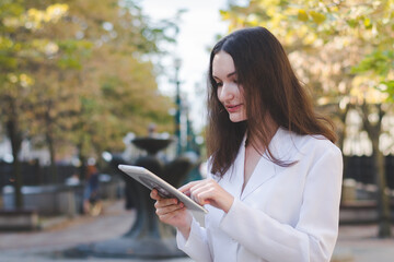 Fototapeta premium Beautiful white business woman with a tablet in an urban environment