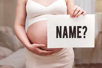 Pregnant woman holding paper with text Name and question mark, home living room background