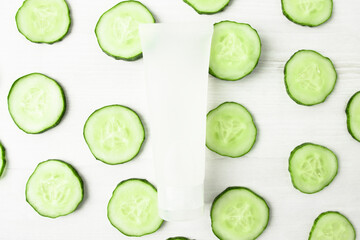 Package of lotion, tonic for moisturizing and care of the body and face with slices of fresh cucumber, top view.