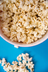 Bol de palomitas de maíz sobre fondo azul