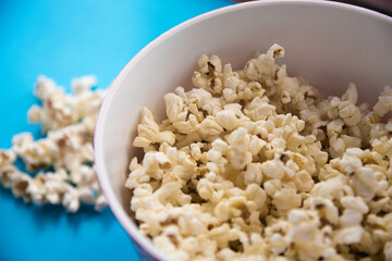 Bol de palomitas de maíz sobre fondo azul