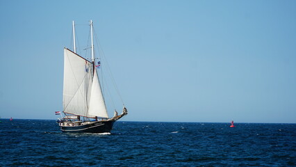 Fototapeta na wymiar Rostock, Germany - 08.13.2022: Hanse Sail, old sailboat with white sails