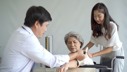 Asian young woman taking her mother to see a doctor in hospital or clinic and having a medical treatment consulting.