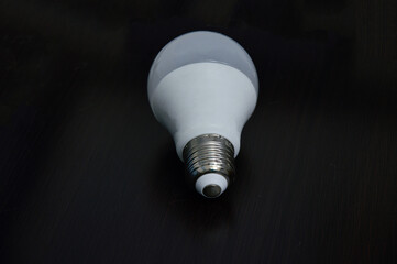 white light bulb empty on black wooden floor
