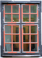 Antique wooden window with a red frame.