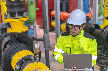 Asian engineer wearing glasses working in the boiler room,maintenance checking technical data of heating system equipment,Thailand people