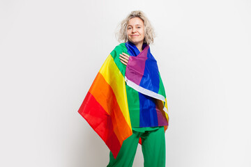 Middle aged woman smiling posing with rainbow LGBT flag