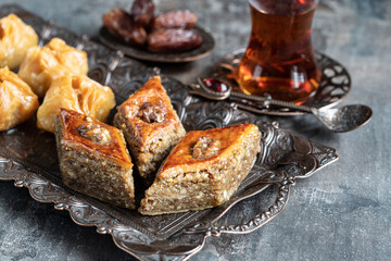 Turkish tea in traditional glass with baklava  on dark background