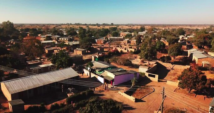 Aerial Panning Shot Of People Walking By Residential Houses In Village - Lusaka, Zambia