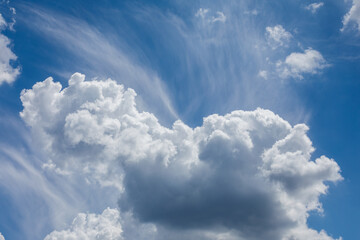 Dramatic cloudscape with blue sky and white fluffy clouds.