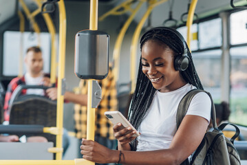 African american woman riding a bus and using a smartphone and headphones © Zamrznuti tonovi