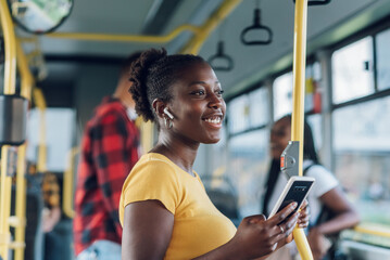 African american woman riding a bus and using a smartphone