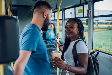 Fototapeta na wymiar Multiracial friends talking while riding a bus in the city