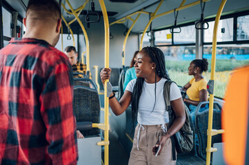 Multiracial friends talking while riding a bus in the city