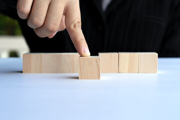 Hand pushing out one wood block, blank template