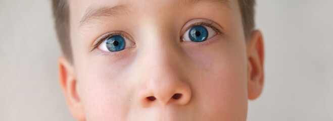 close-up of part of the child's face, serious look of blue eyes, anxious face of boy 8-10 years...