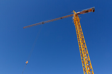 Construction crane on the background of a blue sky. Lifting equipment. Construction