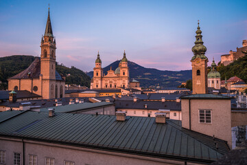 Fototapeta premium Sonnenuntergang über dem Salzburger Dom und Franziskanerkirche und St. Peter