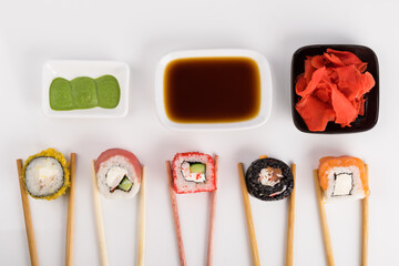 the concept of different rolls and sauces on a light background, top view