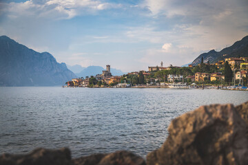 Idyllic coastline in Italy: Blue water and a cute village at lago di garda, Malcesine, sunset