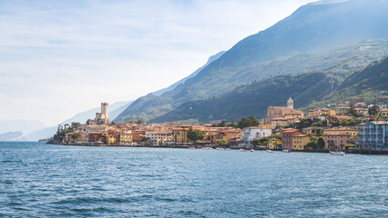 Idyllic coastline scenery in Italy, captured from the water. Blue water and a cute village at lago di garda, Malcesine